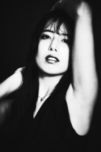 Black and White Portrait for an Actress Portfolio Black and white portrait of a Tokyo talent with her hand behind her head, wearing a sleeveless top.