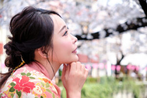 Japanese Model Minami Airi A fanous Japanese actress in traditional kimono in Tokyo, looking thoughtful with cherry blossoms in the background.
