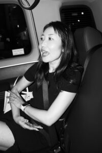 Black and White Lifestyle Portrait by JG Brasseur Portrait of a woman speaking in a taxi, seated and gesturing with her hands, black and white photography.