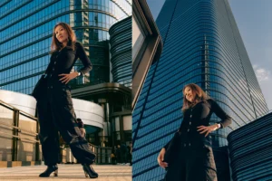 Urban Portraits in Tokyo A Japanese woman posing in a black outfit in front of a modern skyscraper in Tokyo.