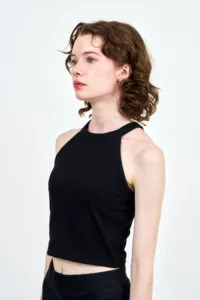 Young female model in black crop top, professional studio portrait for fashion portfolio.