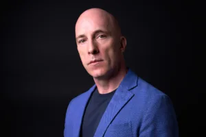 Professional portrait of British author Andrew Rankin, posed in a blue blazer for his next book cover.