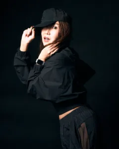 Female model in a black cap and jacket, striking a dynamic pose for a fashion photography session in Tokyo.