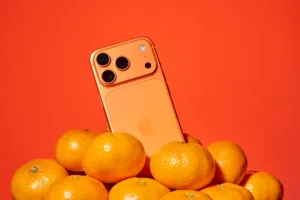 Orange smartphone on mikan oranges, vibrant still life product photography in landscape format by JG Brasseur in Tokyo.