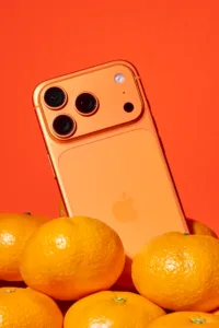Orange smartphone on mikan oranges, vibrant still life product photography in portrait format by JG Brasseur in Tokyo.